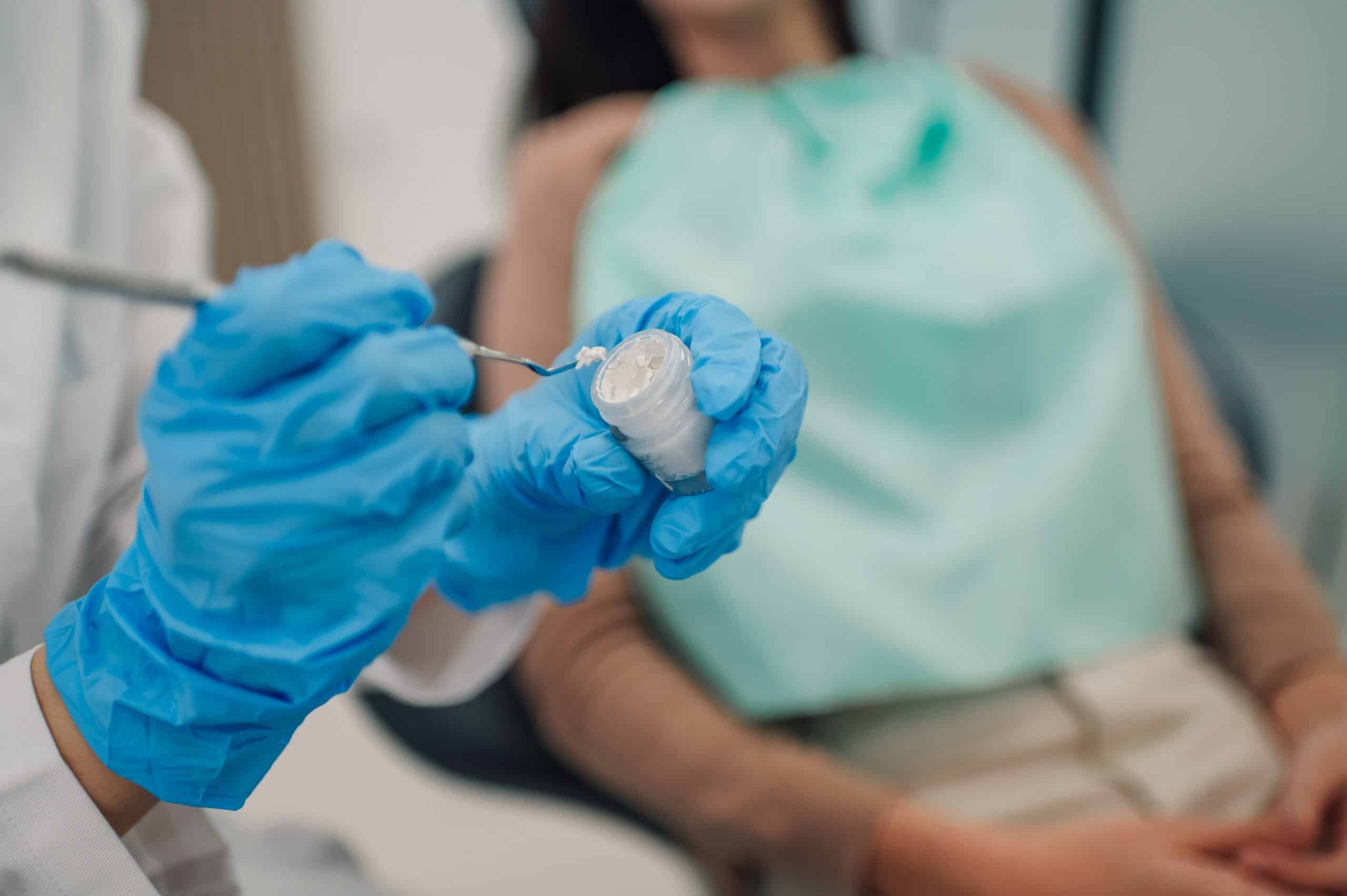 Dentist picking up dental filling material chairside